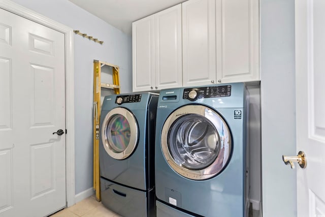 laundry area with cabinets, light tile patterned floors, and independent washer and dryer