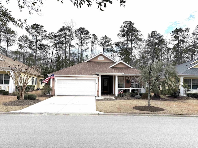 ranch-style home featuring concrete driveway, a porch, an attached garage, and a shingled roof