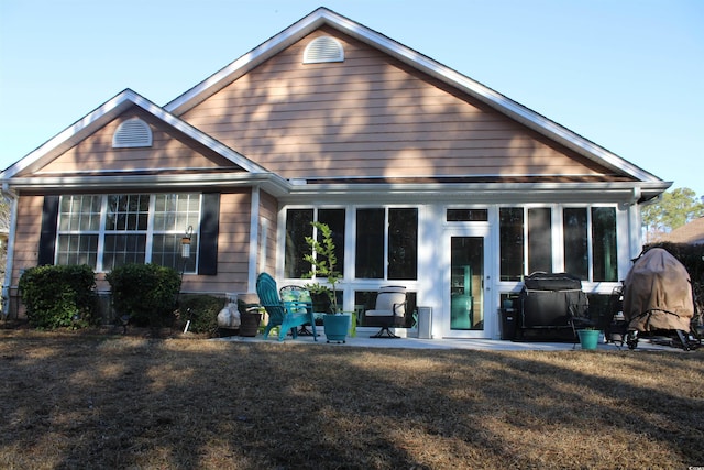 rear view of property featuring a patio area and a lawn