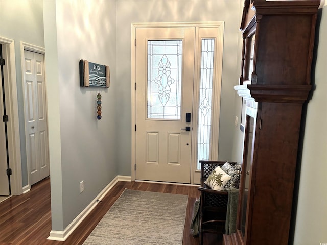 entryway with dark wood finished floors and baseboards