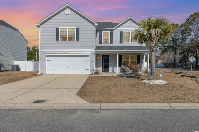 front of property with a garage, a yard, central AC unit, and covered porch