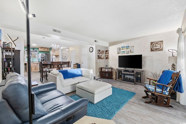 living room featuring an inviting chandelier, sink, and wood-type flooring