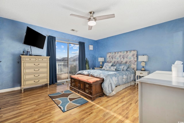 bedroom featuring ceiling fan, access to outside, a textured ceiling, and light wood-type flooring