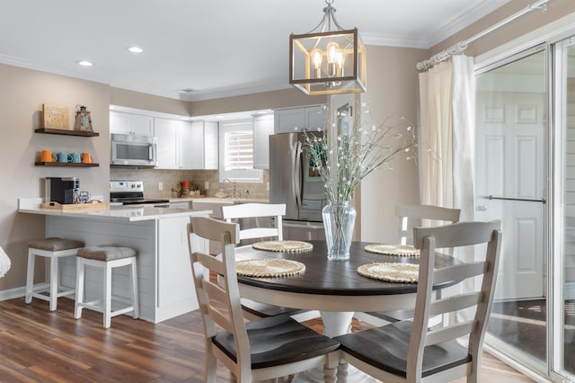 dining area with ornamental molding, dark hardwood / wood-style floors, and a notable chandelier