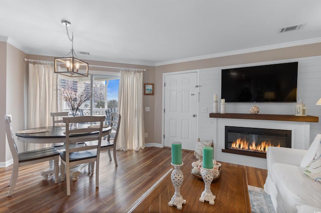 living room featuring crown molding, a notable chandelier, and hardwood / wood-style flooring