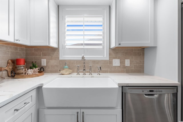 kitchen with sink, tasteful backsplash, light stone countertops, white cabinets, and stainless steel dishwasher