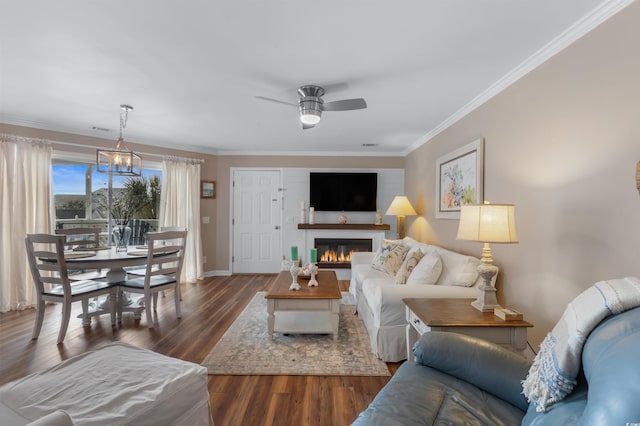 living room featuring dark hardwood / wood-style flooring, crown molding, and ceiling fan