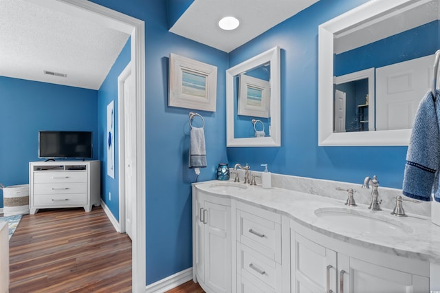 bathroom featuring vanity, hardwood / wood-style floors, and a textured ceiling