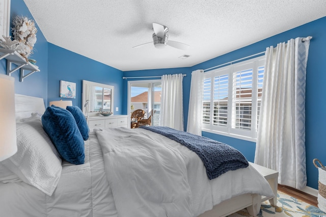 bedroom with wood-type flooring, a textured ceiling, and ceiling fan