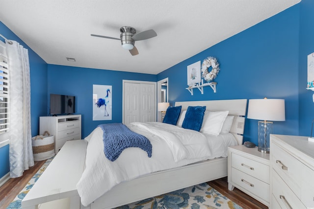 bedroom featuring ceiling fan, dark hardwood / wood-style flooring, and a closet