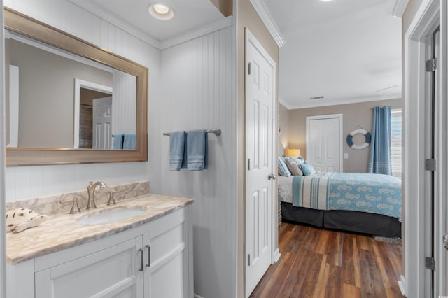 bathroom featuring crown molding, vanity, and hardwood / wood-style floors