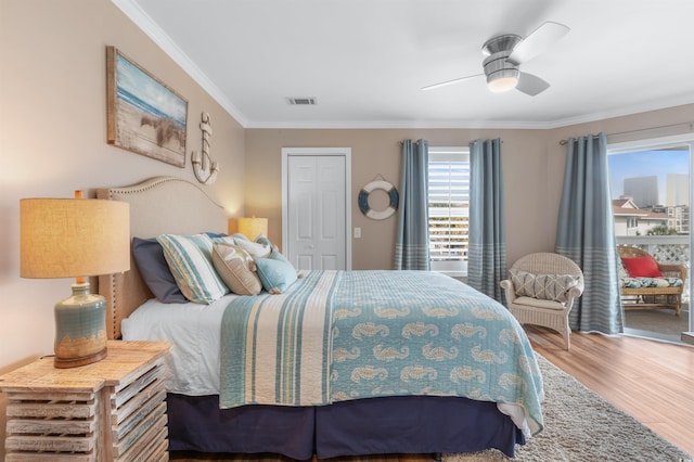 bedroom featuring hardwood / wood-style floors, ornamental molding, and ceiling fan