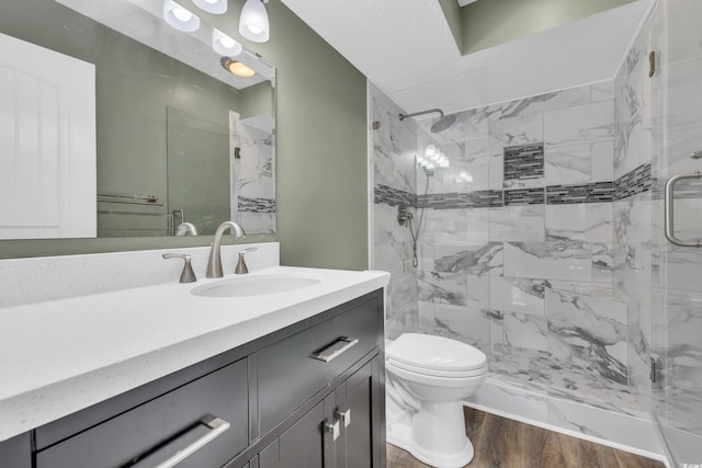 bathroom featuring hardwood / wood-style flooring, vanity, toilet, and a shower with shower door