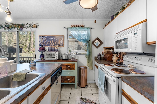 kitchen featuring white cabinetry, sink, white appliances, and a wealth of natural light