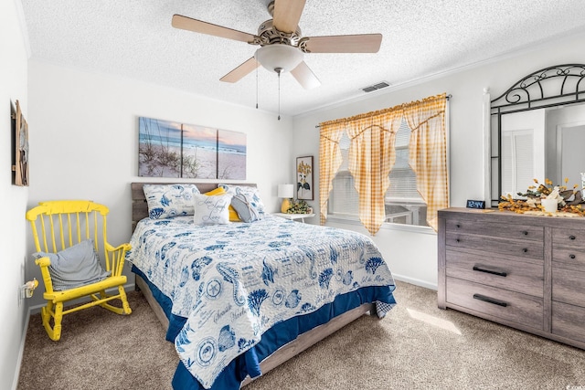 bedroom with ceiling fan, carpet flooring, and a textured ceiling