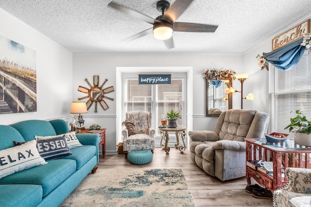 living room featuring plenty of natural light, ornamental molding, and wood-type flooring