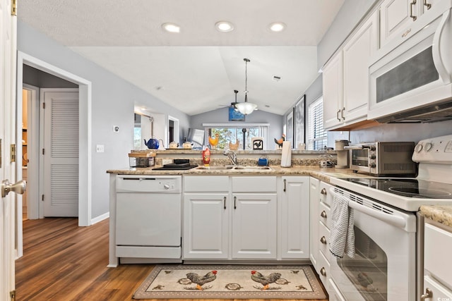 kitchen with dark hardwood / wood-style floors, lofted ceiling, sink, white cabinets, and white appliances