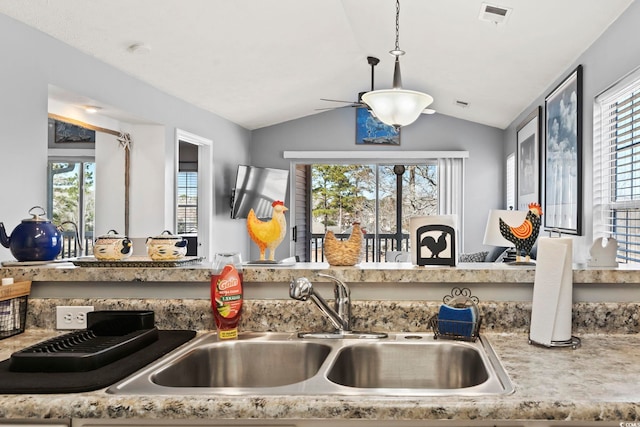 kitchen with vaulted ceiling, decorative light fixtures, and sink