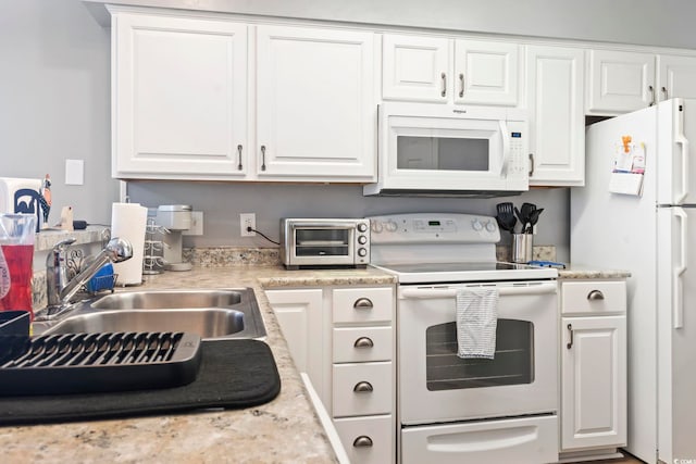 kitchen featuring white cabinetry, sink, white appliances, and light stone counters