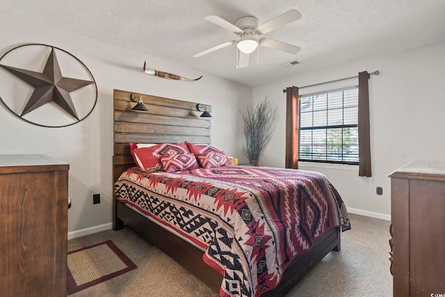 bedroom featuring ceiling fan, light colored carpet, and a textured ceiling