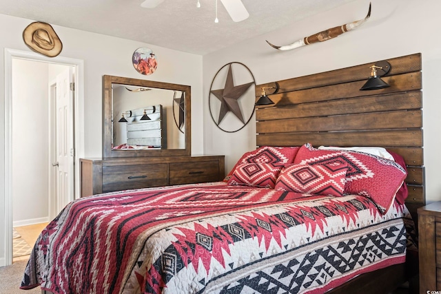 carpeted bedroom featuring a textured ceiling and ceiling fan