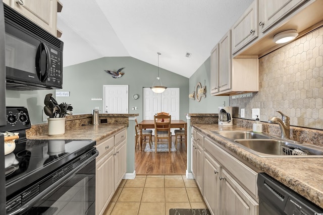 kitchen with sink, black appliances, light tile patterned flooring, decorative light fixtures, and vaulted ceiling