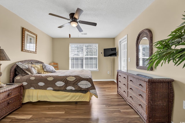 bedroom featuring ceiling fan, dark hardwood / wood-style flooring, and a textured ceiling