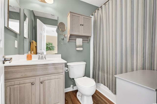 bathroom featuring wood-type flooring, walk in shower, vanity, and toilet