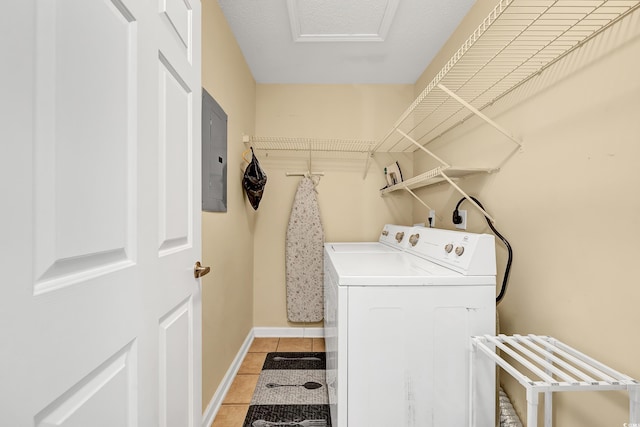 washroom with electric panel, washing machine and dryer, and light tile patterned floors