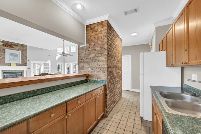 kitchen featuring brick wall, sink, ornamental molding, light tile patterned floors, and ceiling fan