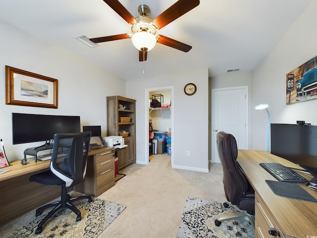 office space featuring visible vents, ceiling fan, light carpet, and baseboards