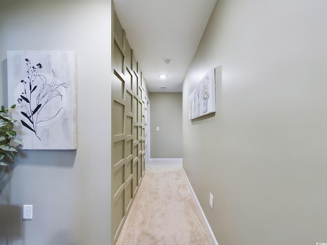 hall with light colored carpet and baseboards