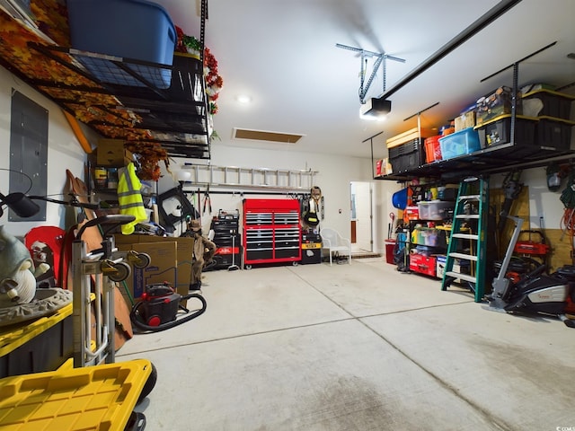 garage with a workshop area, electric panel, and a garage door opener