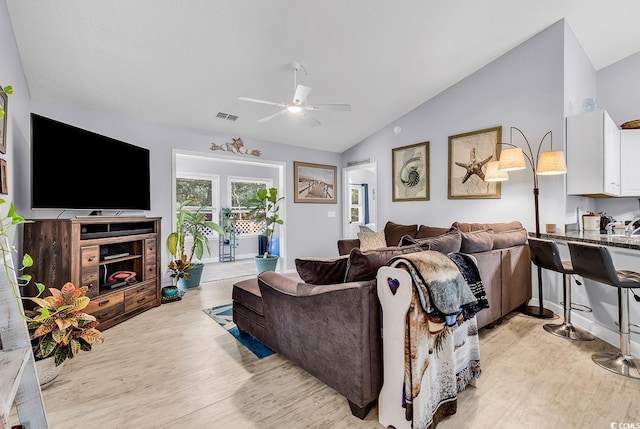 living room featuring ceiling fan, lofted ceiling, and light wood-type flooring