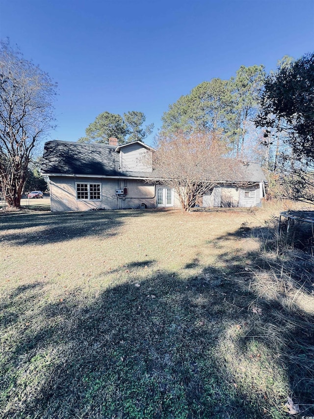 back of property with a lawn