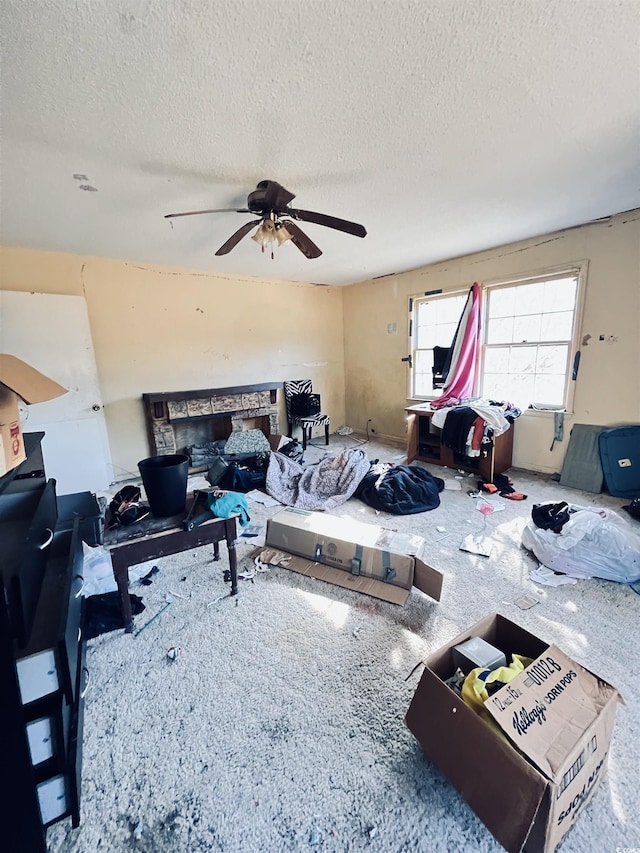 living room featuring ceiling fan and a textured ceiling