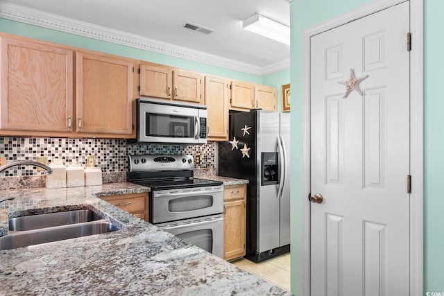 kitchen featuring light stone counters, sink, backsplash, and stainless steel appliances