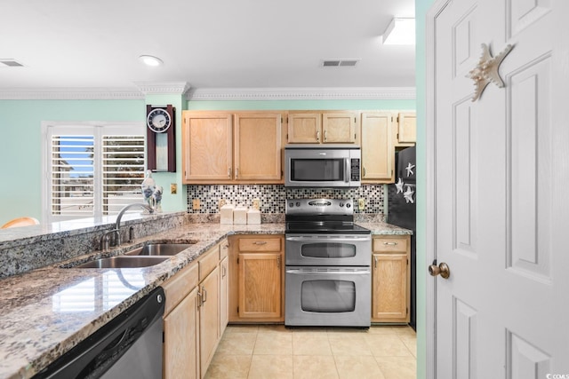 kitchen featuring tasteful backsplash, appliances with stainless steel finishes, sink, and light stone counters