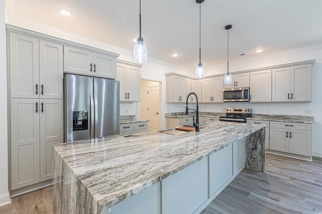 kitchen featuring stainless steel appliances, pendant lighting, ornamental molding, and a spacious island