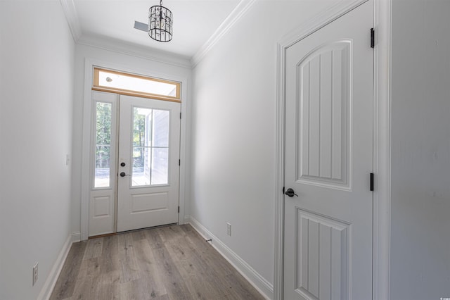 doorway to outside featuring light wood-type flooring, baseboards, and crown molding