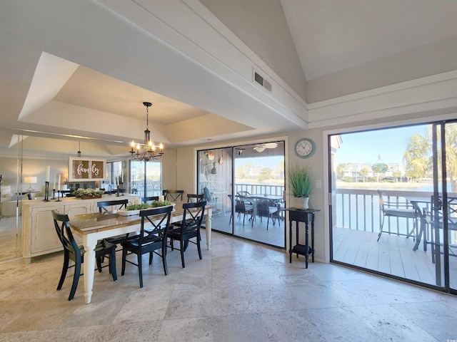 dining room featuring lofted ceiling, a tray ceiling, and a notable chandelier