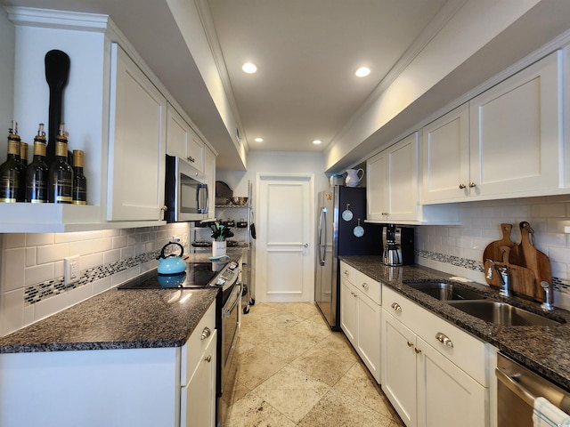 kitchen with appliances with stainless steel finishes, tasteful backsplash, white cabinetry, sink, and dark stone countertops