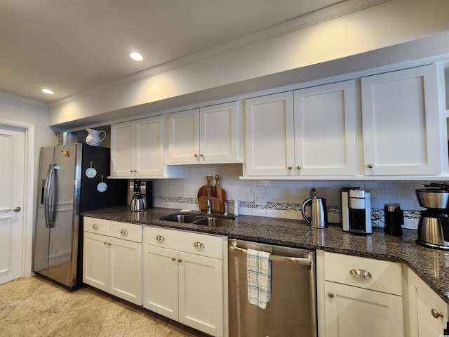 kitchen with tasteful backsplash, white cabinets, appliances with stainless steel finishes, and dark stone counters