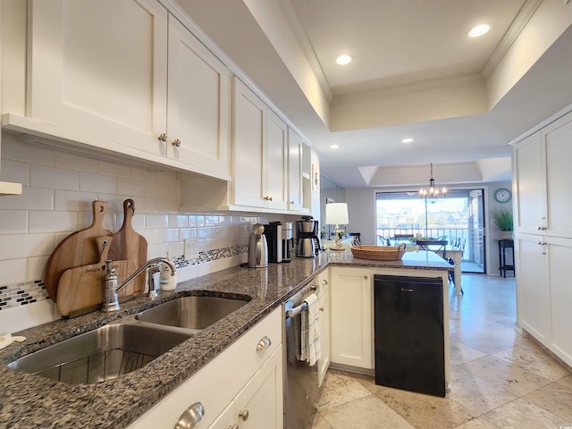 kitchen with sink, white cabinets, dark stone counters, kitchen peninsula, and a raised ceiling