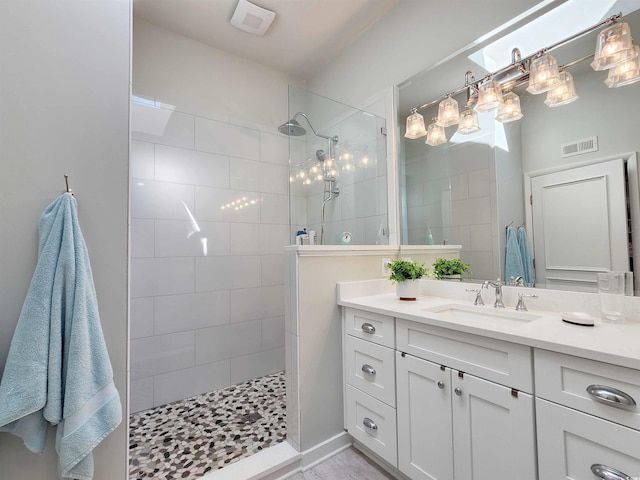 bathroom with vanity and a tile shower