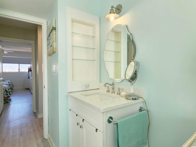 bathroom featuring vanity, wood-type flooring, and a textured ceiling