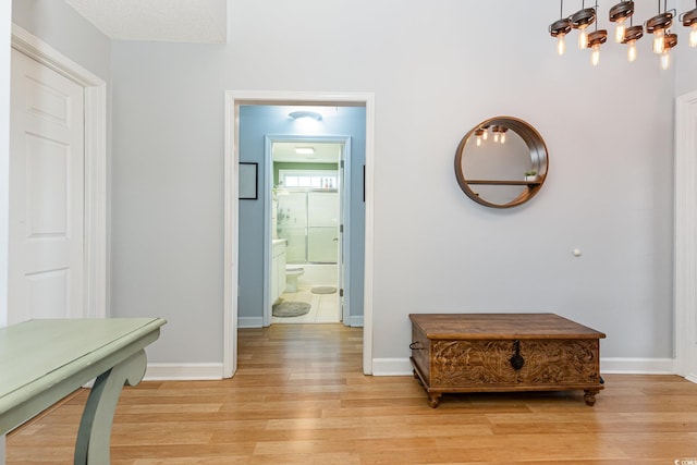 corridor with baseboards and light wood finished floors