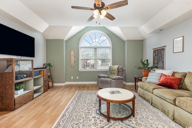 living area featuring a ceiling fan, vaulted ceiling, baseboards, and wood finished floors