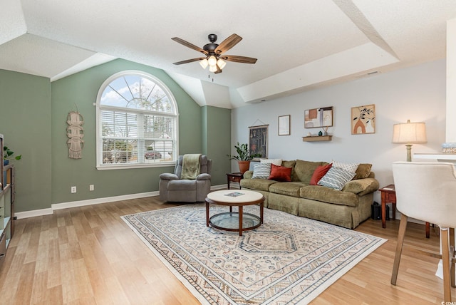 living area with lofted ceiling, light wood-style floors, visible vents, and a ceiling fan