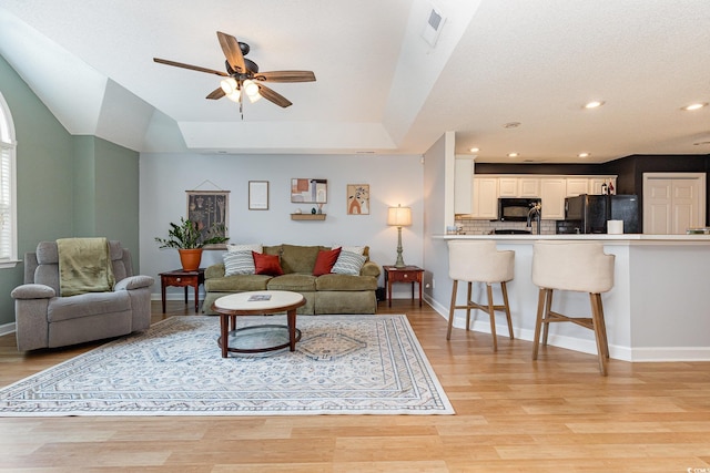 living area with recessed lighting, visible vents, ceiling fan, light wood-type flooring, and baseboards